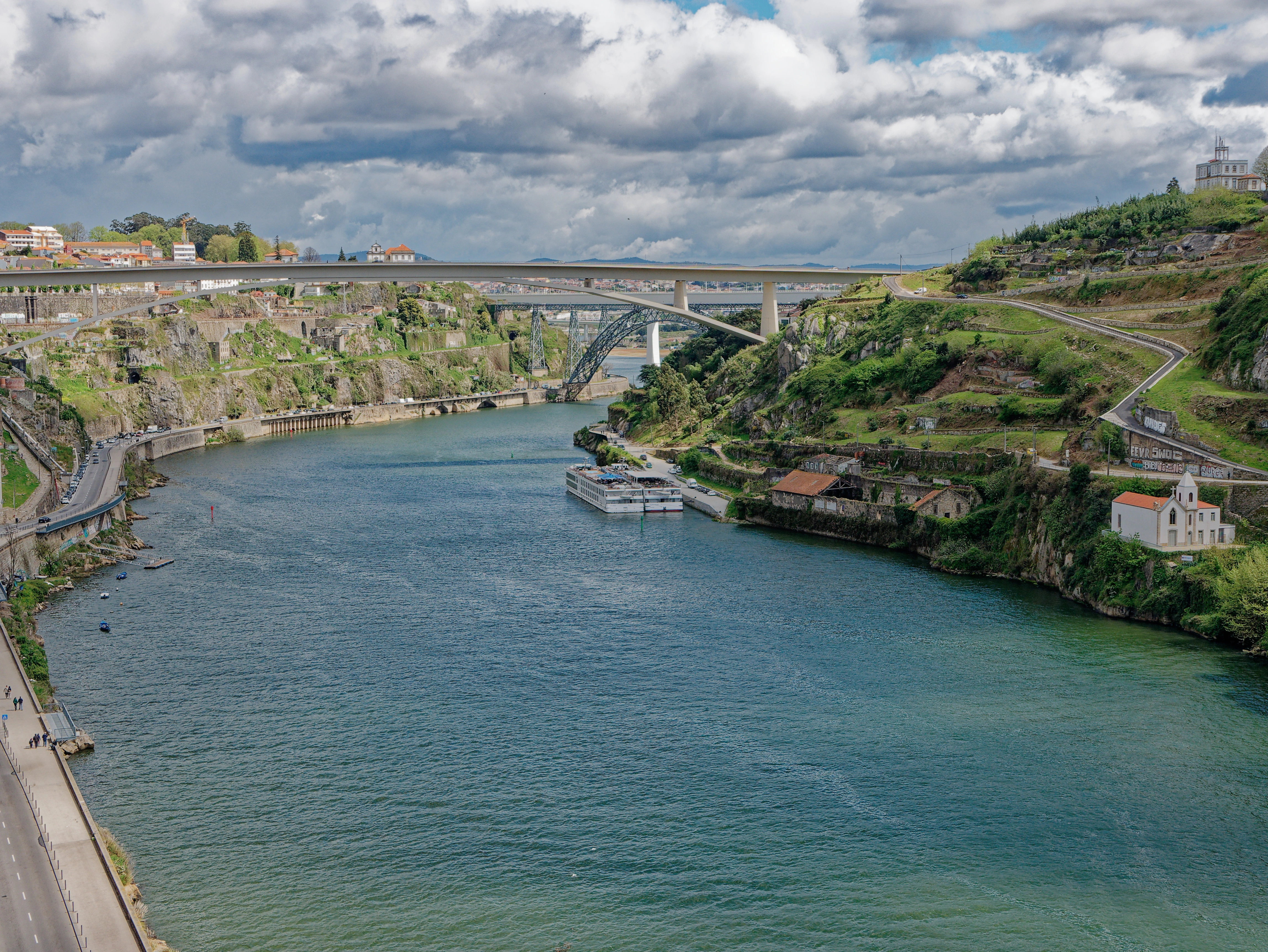 Przełom rzeki Douro w Porto z widokiem na mosty i strome zielone zbocza