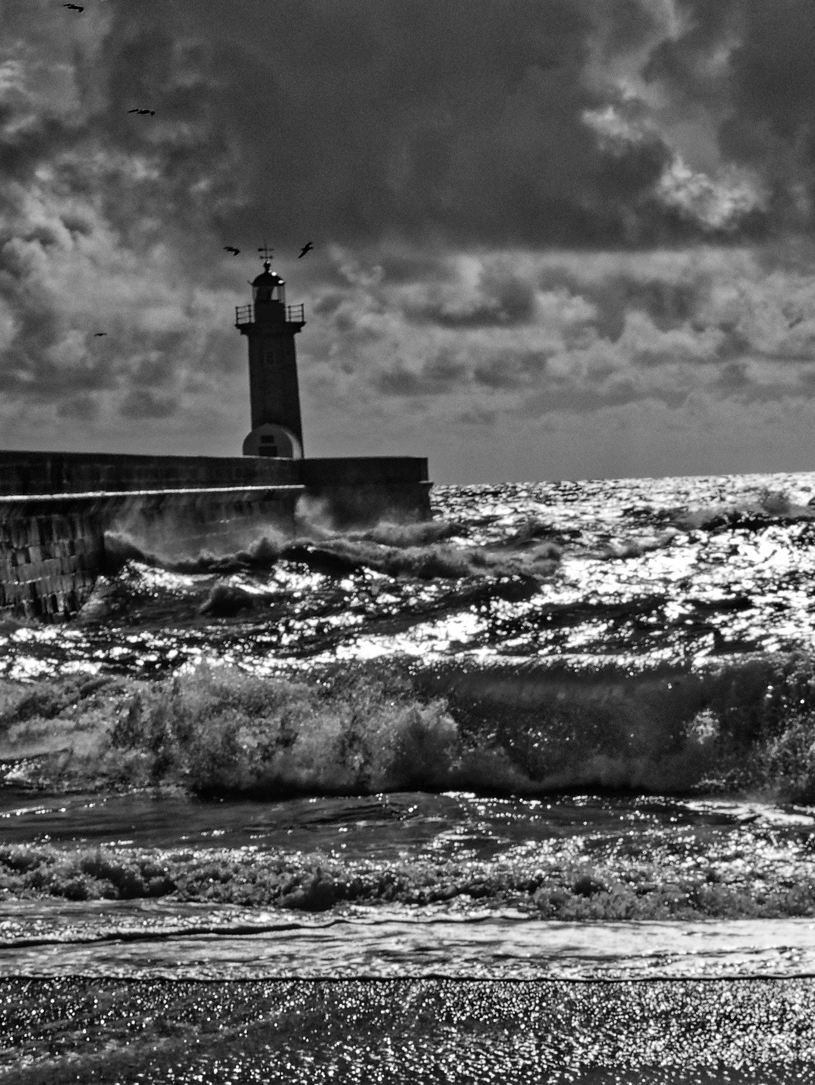 Latarnia morska Farol de Felgueiras w Foz do Douro i potężne fale oceanu w czerni i bieli